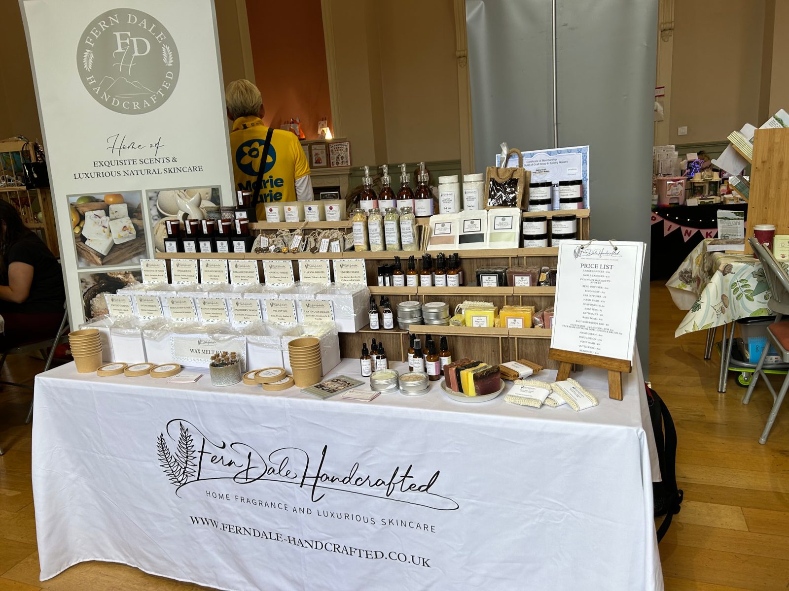 Fern Dale Handcrafted market stall with a banner, soaps, balms and a handwritten price list