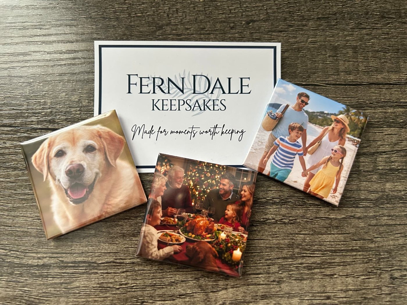 A Fern Dale Keepsakes card reading Made for moments worth keeping, with photo magnets on wood